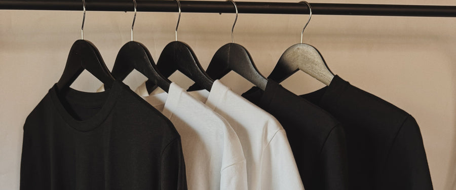 Black and white tees on a rack, ready to print